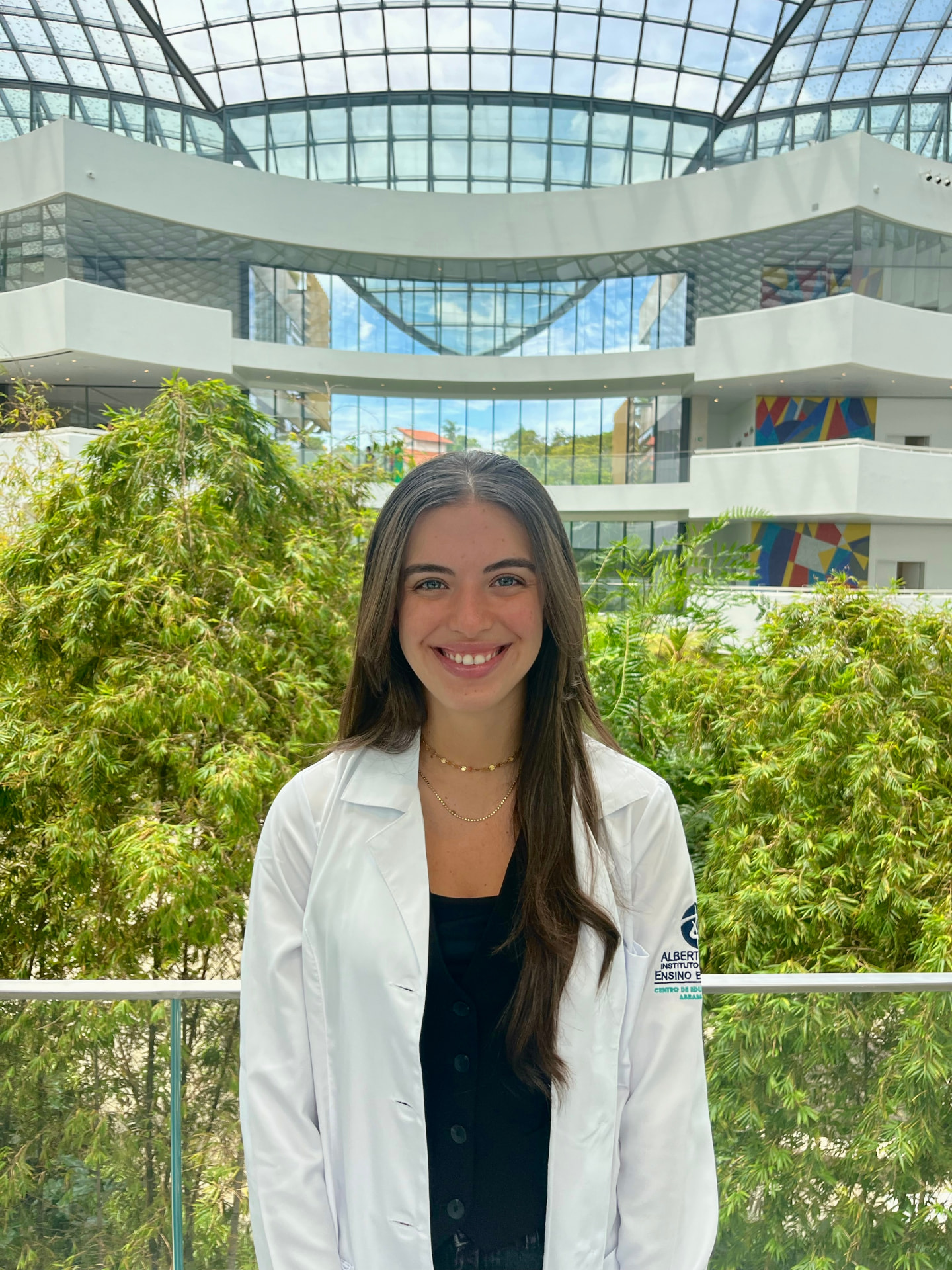 Julia Delgado, psicóloga, sorrindo em ambiente com plantas